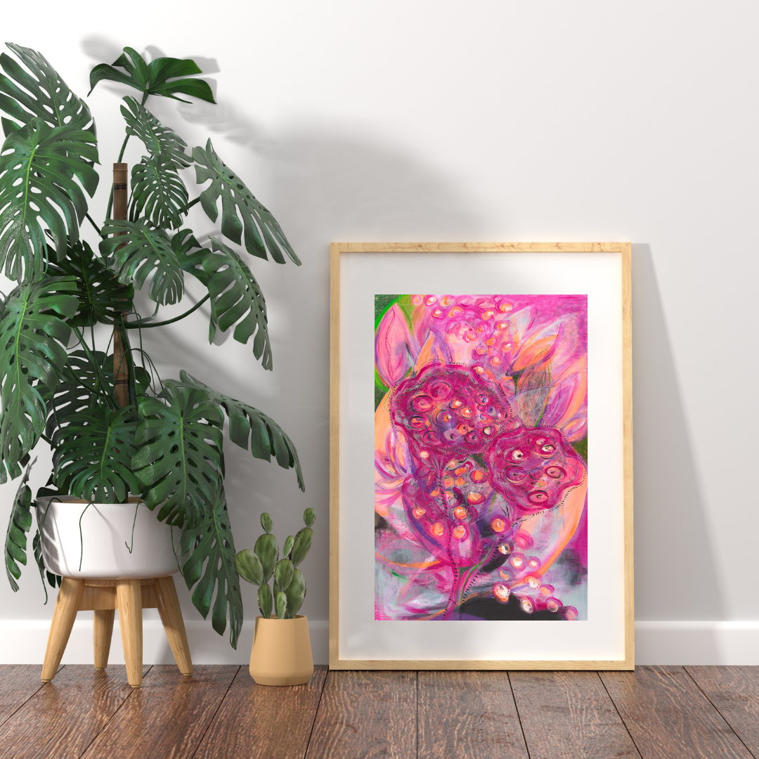Framed abstract art piece on a wall with plants in the foreground