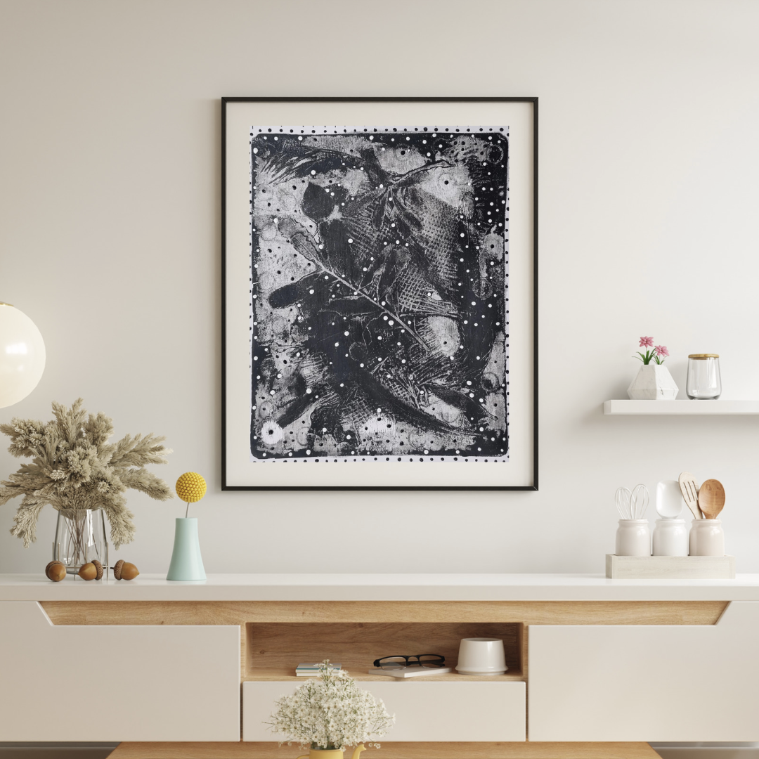 Framed black and white abstract art piece on a wall above a wooden console table.