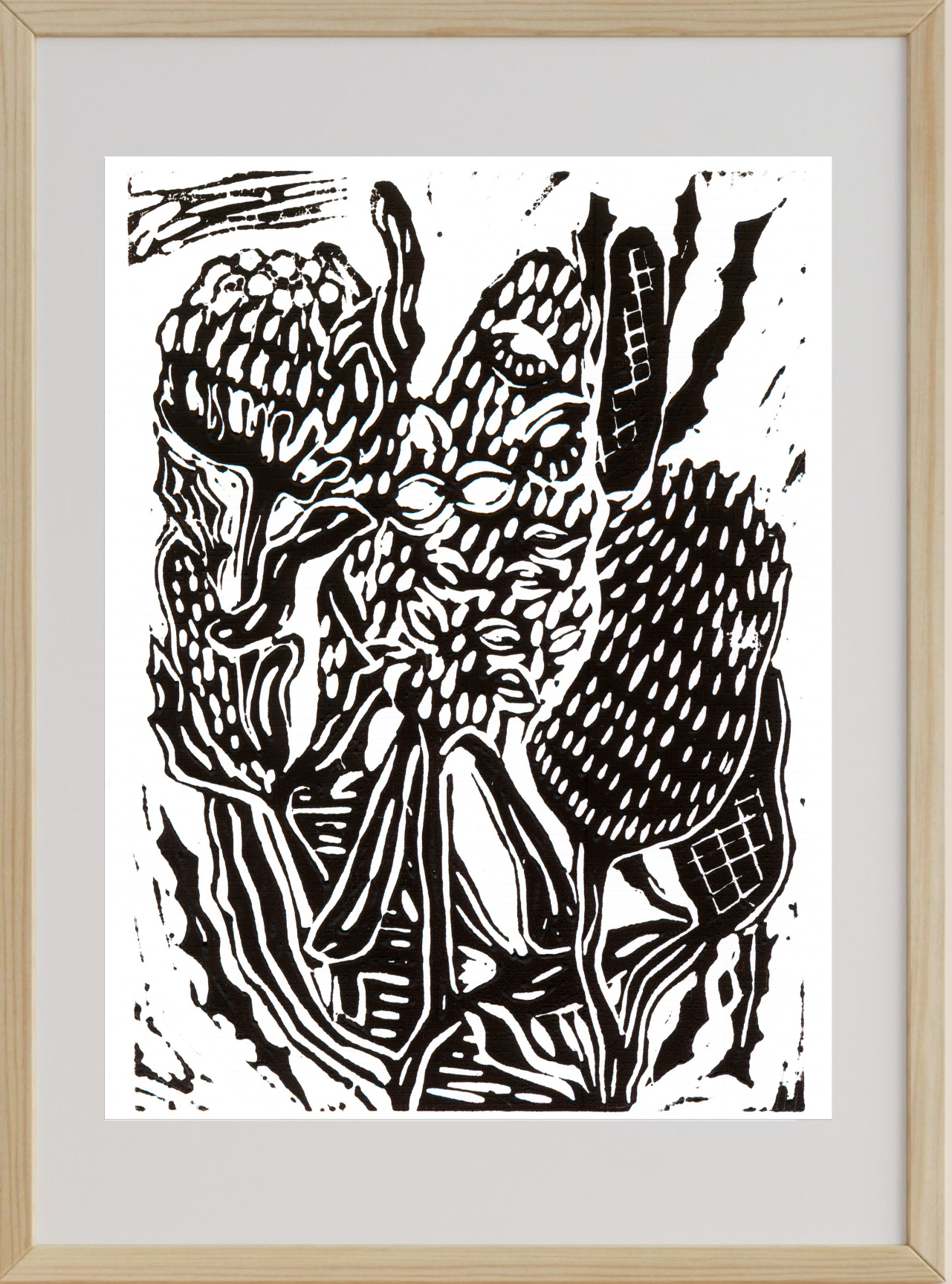 Black and white linocut print of a mask on a light gray background with a wooden frame.