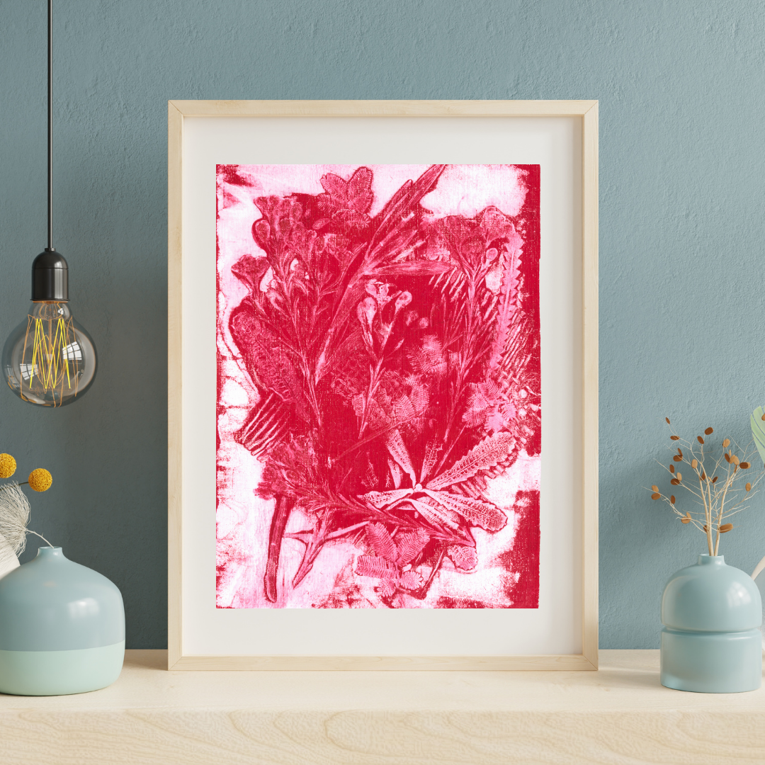 Framed pink floral artwork on a blue wall with decorative vases and a light bulb.