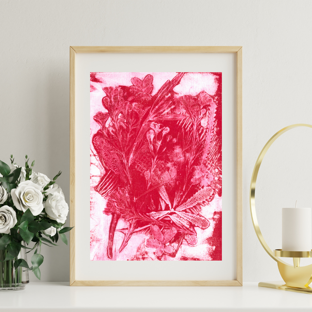 Framed pink floral artwork on a white wall with decorative items.