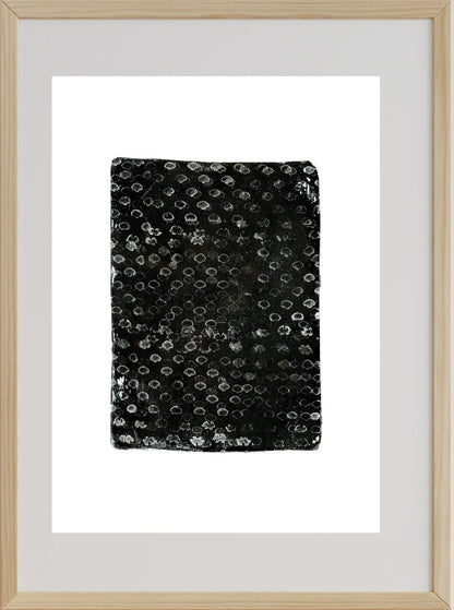A framed artwork featuring a black and white pattern of dots filling the frame, representing a abstract landscape or texture.