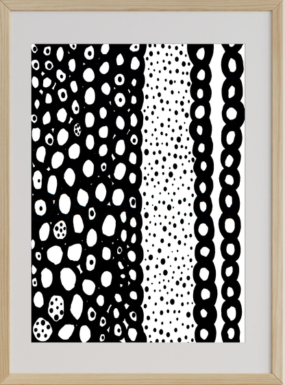 Framed artwork with black and white abstract patterns on a light wood frame.