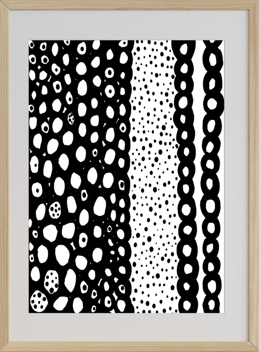 Framed artwork with black and white abstract patterns on a light wood frame.