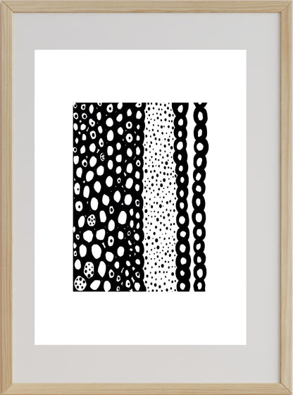 A framed artwork featuring various geometric patterns in black and white, with a wooden frame.