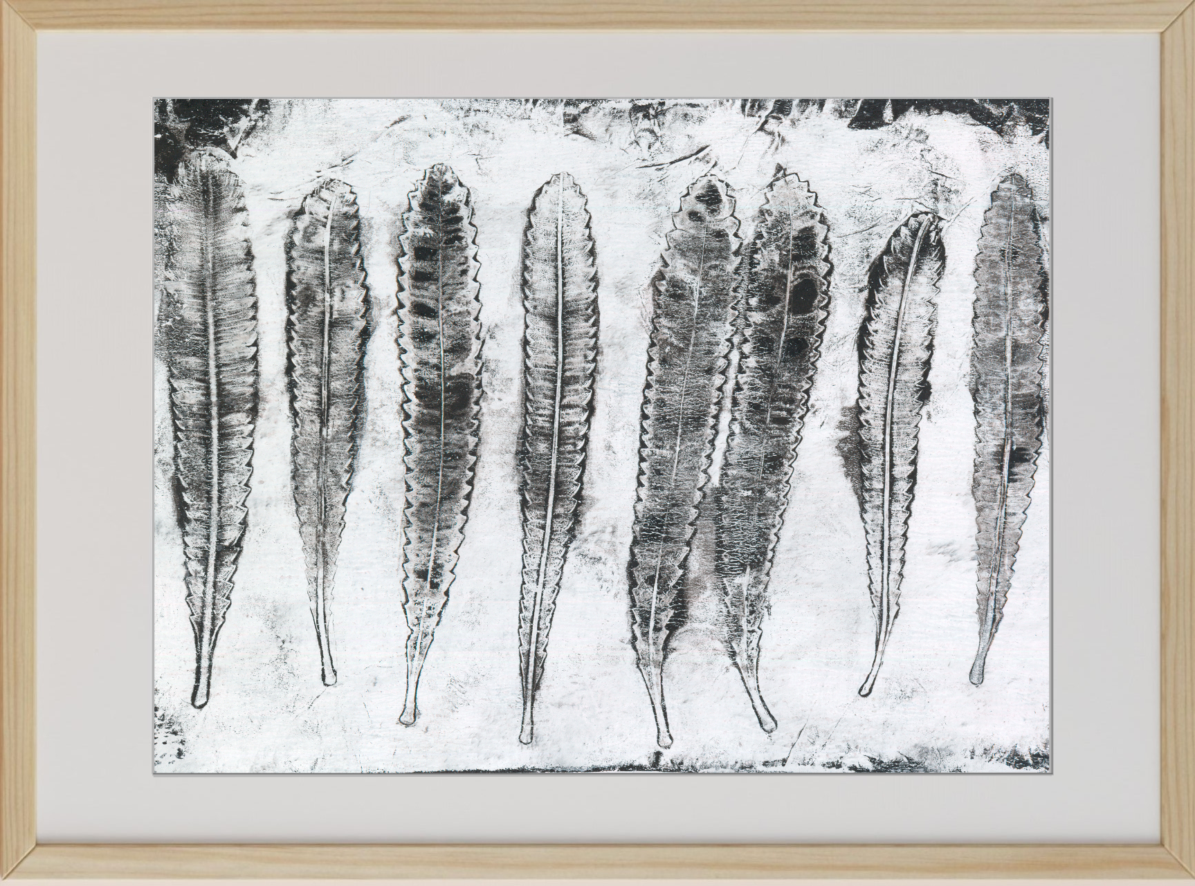 Framed black and white artwork of leaf-like shapes on a textured background